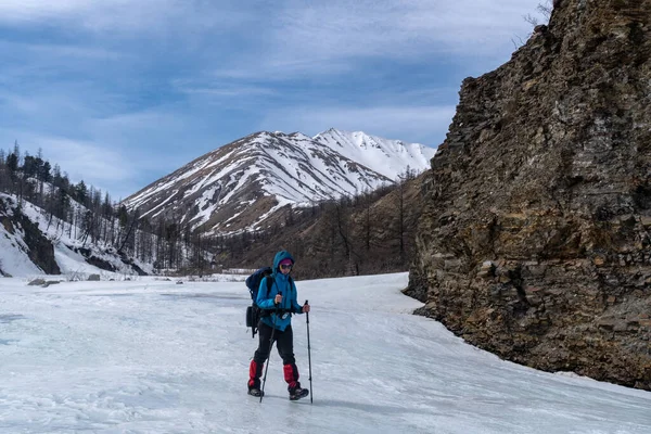 山の中を氷の川に沿って歩く少女 — ストック写真
