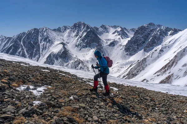 Girl with a backpack climbs the mountain