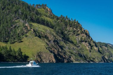 Tekne Baykal Gölü 'nün kayalık kıyılarından geçiyor.