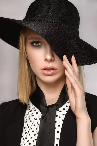 Красивая блондинка держит шляпу одной рукой закрыть глаза — стоковое фото