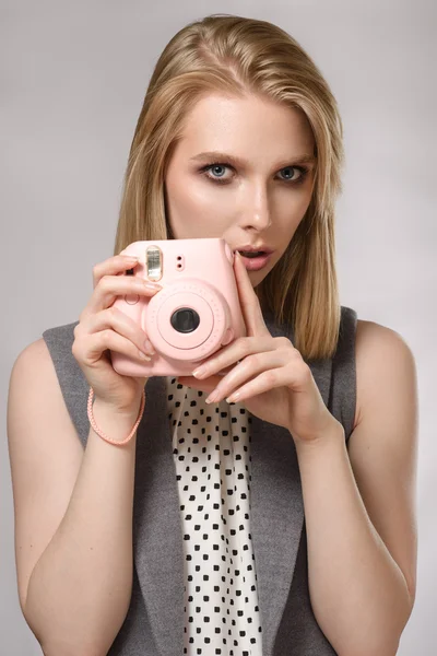 Красива блондинка з рожевою камерою сміється і посміхається — стокове фото