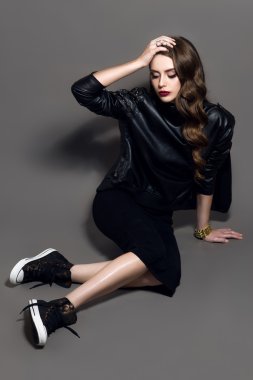 Çekici genç güzel rock tarzı kız aksesuarlar koyu gri arka plan üzerinde siyah deri ceketli