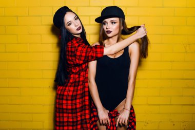 İki genç mutlu hipster kız eğlenmek, gülümseyen, gülerek, atlama, kentsel sarı duvar arka plan yakınında yürüyüş, yaz dinlenmek kavramı