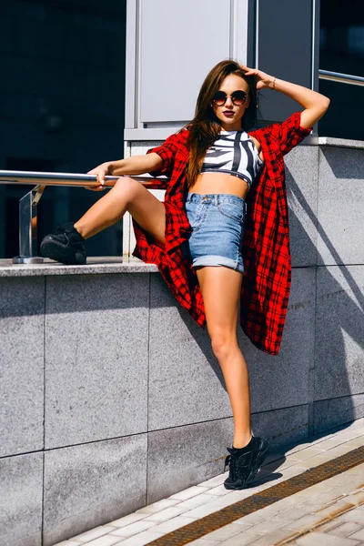 Hermosa chica hipster sexy joven posando en gafas de sol fuera en la calle —  Fotos de Stock