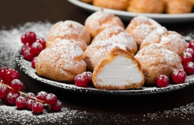 Siyah saç, koyu arka plan üzerinde kremalı profiterol