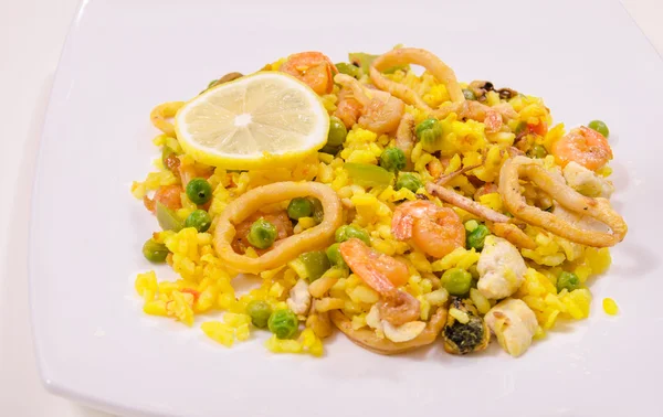Paella with chicken and seafood, white background