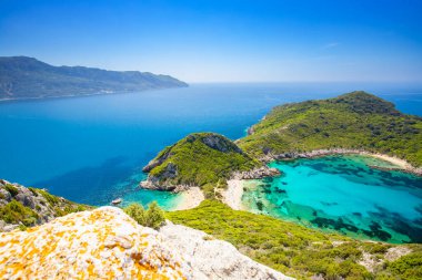 Yunanistan 'ın Korfu adasındaki Porto Timoni' de kristal berrak ve masmavi suyla sahilin manzarası, arka plan veya duvar kağıdı