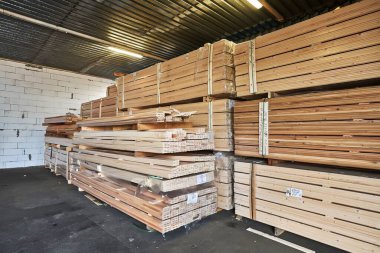 Geniş bir depoda istiflenmiş kereste kalasları, farklı ahşap çeşitleri ve düzenli depolama, inşaat ve ahşap ihtiyaçları için ideal.