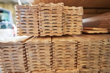 Depolama alanında istiflenmiş ahşap kalaslar, doğal dokularını ve desenlerini vurguluyorlar, çeşitli inşaat ve ahşap işçiliği uygulamaları için mükemmel.