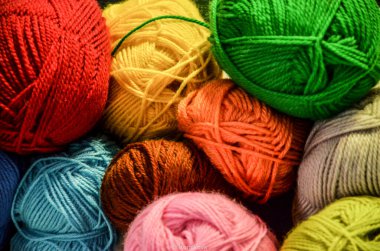 Çeşitli renk ve dokularda iplik topları yaratıcılığa ve sanatsal ifadeye ilham veren görsel olarak çekici bir sahne yaratıyor.