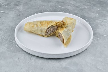 Lezzetli doldurulmuş ekmek beyaz bir tabakta güzelce düzenlenmiştir. Yemek meraklıları için lezzetli ve davetkar sunumu vurgular.