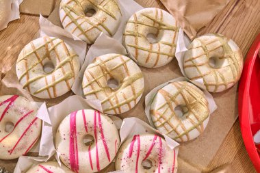 Ev yapımı donut şekilli sabun, sade ahşap bir yüzeyde sergileniyor, şenlikli renkler ve dokular, Noel ve yeni yıl hediyeleri için mükemmel.