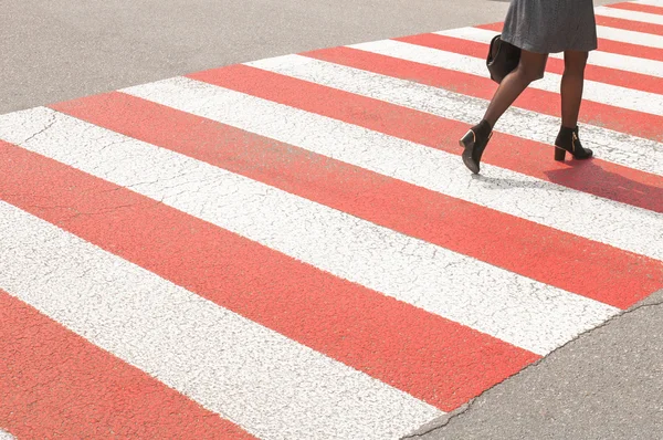 Woman on red and white pedestrian crossing, asphalt road, zebra crossing — Stock Photo, Image