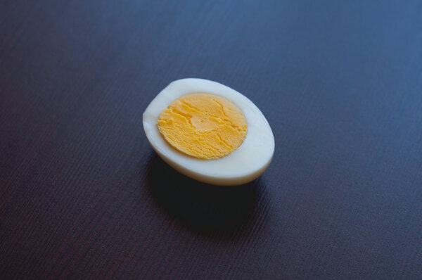 half boiled egg on a dark background