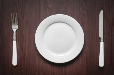 boş tabak kaşık ve çatalı ahşap zemin üzerinde