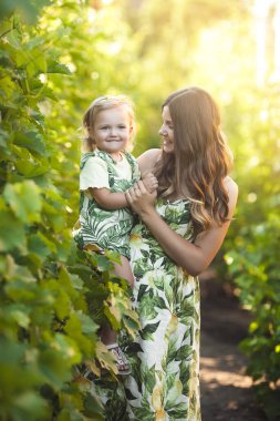 Genç, çekici anne ve küçük kızı dışarıda. Güzel aile.