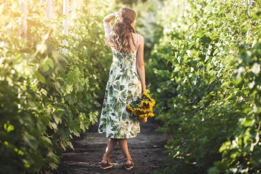 Ayçiçekli çekici genç bayan. Yazın açık havada güzel bir kadın.