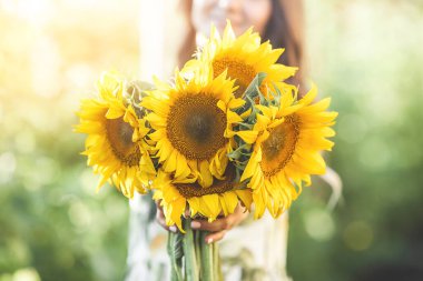 Ayçiçeği tutan güzel bir kadın. Yazın bir buket çiçek..