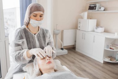 Kozmetikçi yüz ameliyatı yapıyor. Yüz masajı. Cilt bakımı