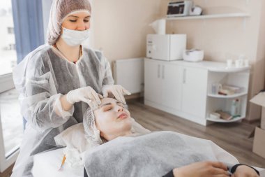 Kozmetikçi yüz ameliyatı yapıyor. Yüz masajı. Cilt bakımı