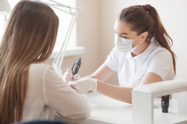 Güzellik salonunda manikür. Manikür yapan kadın.