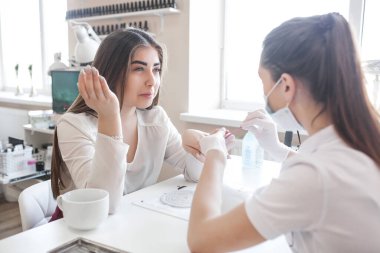 Güzellik salonunda manikür. Manikür yapan kadın.