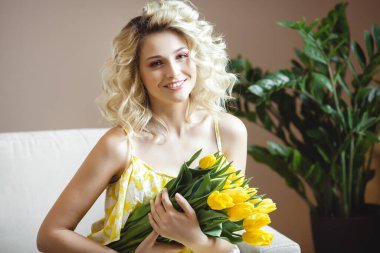 Sarı lale buketli güzel sarışın kadın.