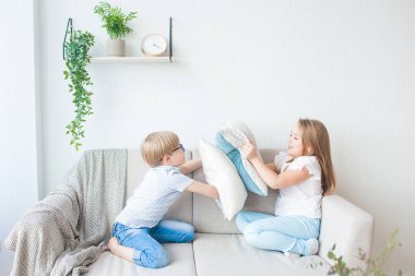 Şirin çocuklar içeride eğleniyor. Yastık savaşı. Çocuklar birlikte oynuyor..