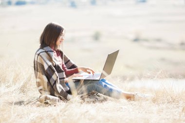 Dışarıda uyanan bir kadın. Kamp yapmak için uzaktan kumanda. Bilgisayarda kadın yazma.