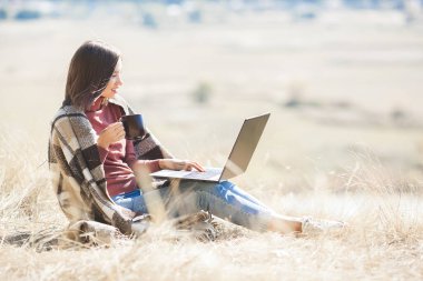 Dışarıda uyanan bir kadın. Kamp yapmak için uzaktan kumanda. Bilgisayarda kadın yazma.