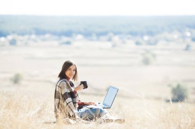 Dışarıda uyanan bir kadın. Kamp yapmak için uzaktan kumanda. Bilgisayarda kadın yazma.