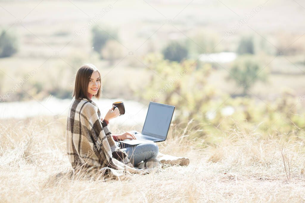 Woman woking outdoors. Remote work on camping. Female typing on pc.