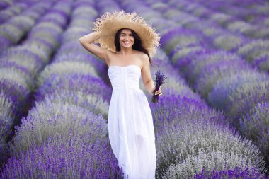 Lavanta tarlasında güzel bir genç kadın. Aroma konsepti. Açık havada çekici genç bir bayan..