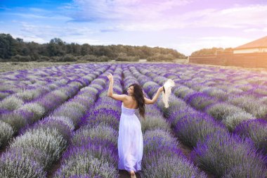 Lavanta tarlasında güzel bir genç kadın. Aroma konsepti. Açık havada çekici genç bir bayan..