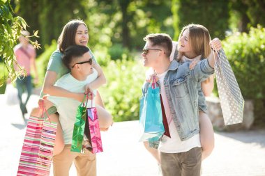 Bir grup insan eğleniyor ve alışveriş yapıyor. Alışveriş çantalı arkadaşlar..
