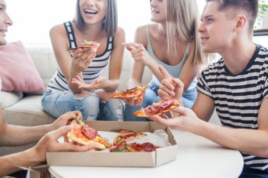 Pizza yiyen gençler. Bir grup arkadaş içeride öğle yemeği yiyor. Komik arkadaşlar birlikte..
