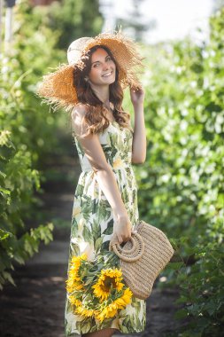 Bir buket ayçiçeğiyle çekici sarışın kadın. Alerjisi olmayan konsept. Yazın çiçekli bir kadın.