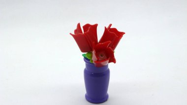 Mor Vazodaki Kırmızı Plastik Çiçek Oyuncağı Beyaz Arkaplanda İzole Edildi