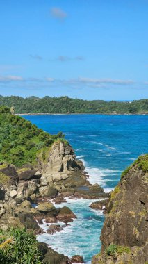 Mavi gökyüzünün altındaki güzel sahil kayalıkları manzarası