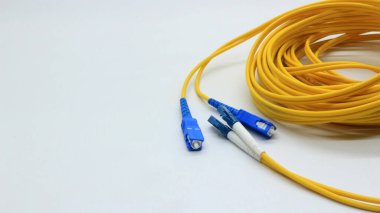 Beyaz arkaplanda izole edilmiş ağ ve veri iletişimi için bağlantıları olan sarı fiber optik kablo