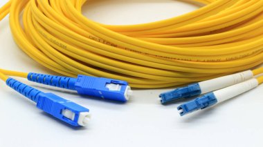 Beyaz arkaplanda izole edilmiş ağ ve veri iletişimi için bağlantıları olan sarı fiber optik kablo