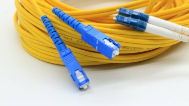 Beyaz arkaplanda izole edilmiş ağ ve veri iletişimi için bağlantıları olan sarı fiber optik kablo