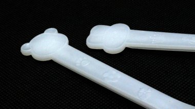 Siyah arka planda izole edilmiş bebek beslemesi için plastik kaşık ve çatal.