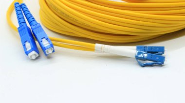 Beyaz arkaplanda izole edilmiş ağ ve veri iletişimi için bağlantıları olan sarı fiber optik kablo