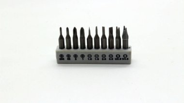 Onarım araçları için beyaz bir arkaplan üzerinde düzgünce düzenlenmiş bir tornavida bit seti