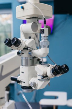 İleri teknoloji göz hekimi mikroskobu, görüş muayenesi ve düzeltmenin önemini vurgulayarak çağdaş bir klinik ortamında geçen çoklu lensler ve ileri optikler içerir.