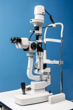 Optalmoloji için tasarlanmış küçük lamba aparatı, hassasiyetini ve özelliklerini vurgulayarak, optimal görüş için mavi bir zemin üzerinde konumlandırılmış
