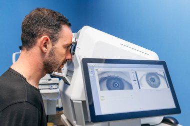 Optimetrist, ileri seviye teşhis makinesiyle hastanın gözünü yakından inceliyor, ekranda detaylı görüntüler gösteriyor, görme ve teknolojinin önemini vurguluyor