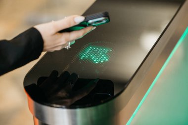 Kadının eli biyometrik bir tarayıcıyla bağlanıyor, güvenli erişim için akıllı telefonu kullanıyor, yenilikçi teknolojiyi ve çağdaş tasarımı canlı bir ortamda vurguluyor