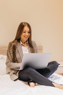 Yatakta dizüstü bilgisayar kullanan bir kadın